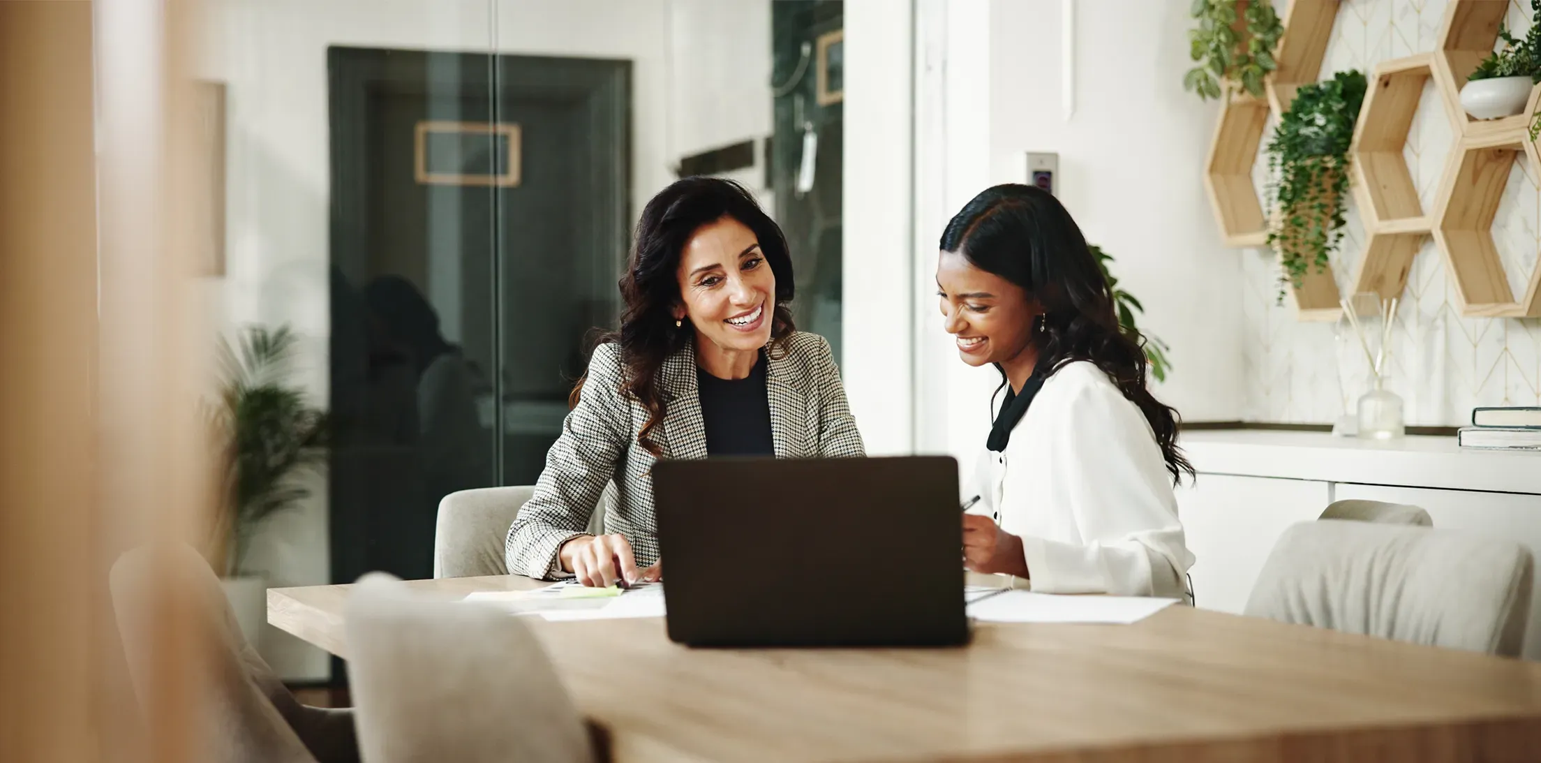 Two colleagues discussing information on a laptop